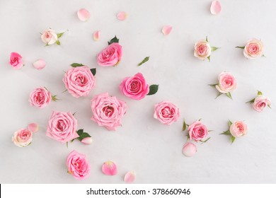 Geassorteerde rozenhoofden. Diverse zachte rozen en bladeren verspreid op een vintage achtergrond, bovenaanzicht