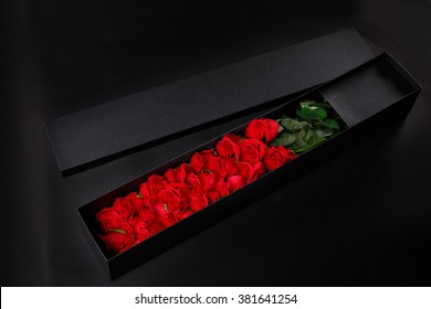 ギフトお土産の黒い​​ボックスにロマンチックな豪華な赤いバラ、黒いスタジオの背景にロゴを配置、春が来る、3 月 8 日