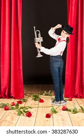 Little girl playing trumpet on stage theater