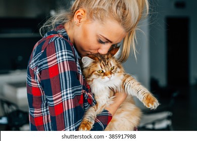 彼女のショウガの猫を抱きしめる美しい少女。親友