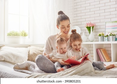 hạnh phúc gia đình yêu thương. người mẹ trẻ đẹp đọc sách cho con gái của mình