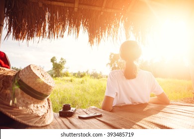 Junges Mädchen sitzt entspannt im Freien und hört an einem schönen sonnigen Tag Musik mit Kopfhörern (absichtliche Sonneneinstrahlung).