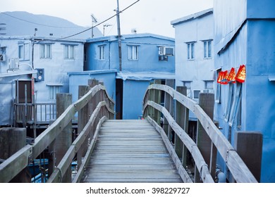 สะพานไม้สู่บ้านเล็ก ๆ ที่ทำจากเหล็ก บ้านอลูมิเนียมตั้งอยู่บนเสาไม้ในหมู่บ้านไทโอ ฮ่องกง