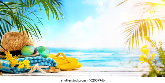 Straw hat, towel, sun glasses and flip flops on beach