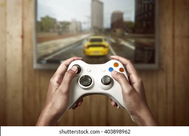 Hand hält Spillkonsol Controller spillt Rennspill um Fernseh