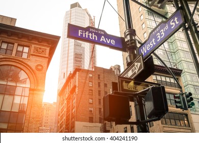 ニューヨーク市の日没時の5番街と西33番街の道路標識 – ニューヨーク・マンハッタンのダウンタウンの都市道路コンセプトの方向 – 温かみのあるドラマチックなフィルターをかけた外観のアメリカの世界的に有名な首都の目的地