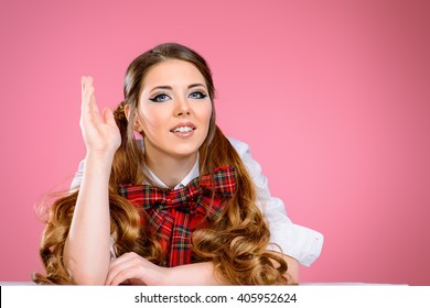 Portret lijepo nasmijane tinejdžerice u školskoj uniformi pozira na ružičastoj pozadini. Anime stil.