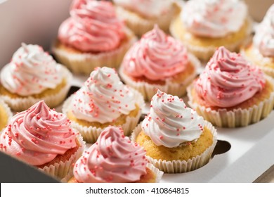 Embalaje de cupcakes, caja de entrega, cupcakes de vainilla con crema rosa y blanca, enfoque selectivo, primer plano
