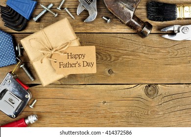 Caja de regalo del Día del Padre con etiqueta y borde de esquina de herramientas y lazos sobre un fondo de madera rústica