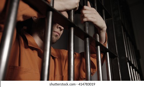 Mann im Gefängnis hinter Gittern - kaukasisches junges Gangmitglied