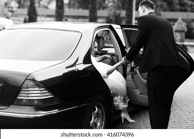 El novio ayuda a la novia a salir del Mercedes negro