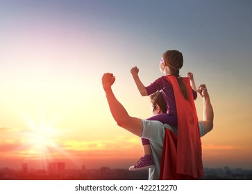 Happy loving family. Father and his daughter child girl playing outdoors. Daddy and his child girl in an Superhero's costumes. Concept of Father's day.