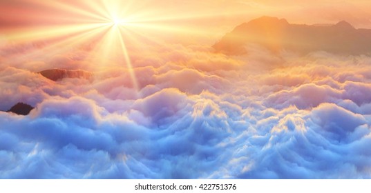 カルパティア山脈の頂上にある霧の海の上に明るい彩度の高い色が夜明けし、朝早く昇る太陽の黄金の光線に照らされた、途方もなく美しいパノラマビューです。