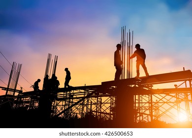 El ingeniero de silueta ordena las órdenes para que los equipos de construcción trabajen en la industria pesada de alta tierra y el concepto de seguridad sobre fondo natural borroso atardecer pastel