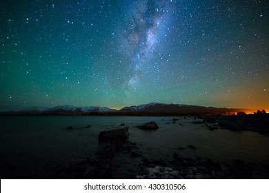 Milchstraße über Lake Tekapo, Neuseeland mit Aurora Australis oder dem Südlicht, das den Himmel erhellt. Rauschen durch hohen ISO; weicher Fokus / flacher DOF aufgrund der verwendeten großen Blende.