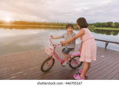 Het meisje en een jongere man zitten op een fiets en kijken naar de natuur.