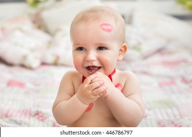 Image of adorable child with red kisses on the skin, happy boy, sitting in the Studio on the bed, angel, romantic holiday, Valentine's Day.
