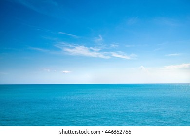 Mooie witte wolken op blauwe lucht boven kalme zee met zonlicht reflectie, Bali Indonesië. Rustige zee harmonie van kalm wateroppervlak. Zonnige lucht en kalme blauwe oceaan. Levendige zee met wolken aan de horizon