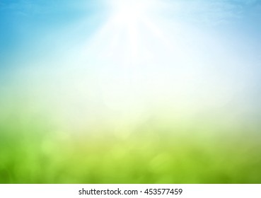 Concepto del día de la tierra: desenfoque abstracto hermoso prado de luz verde suave bokeh y cielo azul sobre fondo de amanecer de otoño
