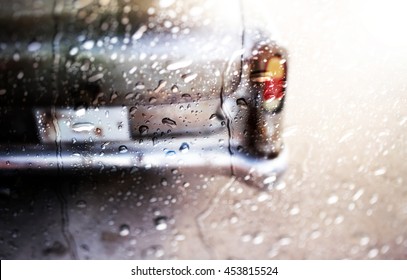Blurry of Rear view of a vintage car fin,view through the window of rainy day.