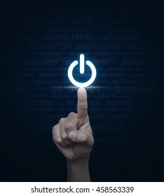 コンピューターのバイナリ コードの青い背景に電源ボタンを押す手