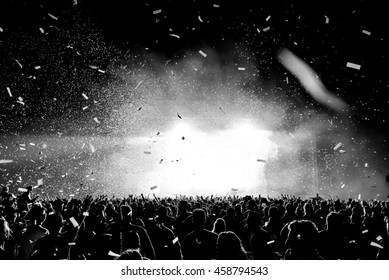 音楽祭 - バックライトで黒と白の紙吹雪シルエット群集。