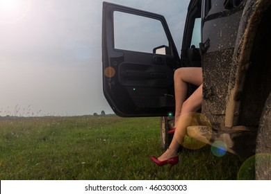 the girl in red shoes behind the wheel of an SUV