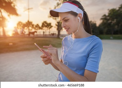 Krásna mladá žena používa aplikáciu vo svojom smartfóne na hranie mobilnej hry v parku