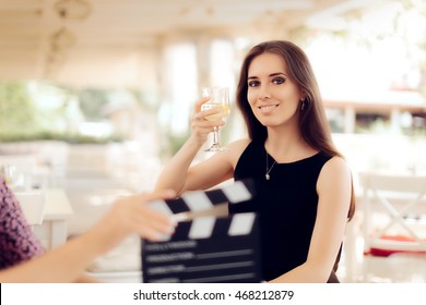 Glückliche Schauspielerin, die ein Glas in einer Filmszene hält - Porträt eines eleganten Mädchens, das in einem Werbevideo auftritt