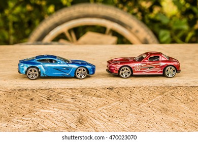 Kereta sukan mainan di luar bandar Dua kereta lumba merah dan biru di trek perlumbaan.