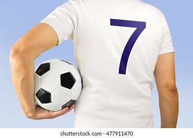 Cropped rearview image of a young man holding a soccer ball under his arms at Madrid