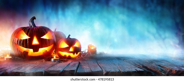 Calabazas de Halloween en madera en un bosque tenebroso en la noche