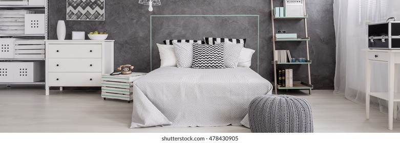 Bright bedroom with marital bed, white commode, rack and cyan wall