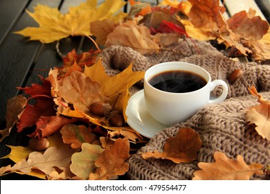 Herfst, herfstbladeren, hete dampende kop koffie en een warme sjaal op houten tafel achtergrond. Seizoensgebonden, koffie in de ochtend, zondag ontspannen en stilleven concept.