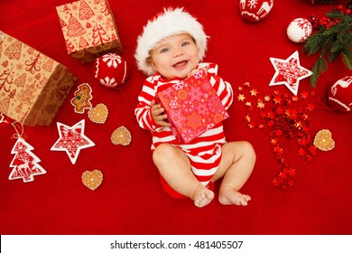 赤ちゃんの最初のクリスマス. 美しい小さな赤ちゃんがクリスマスを祝います。年末年始。サンタの帽子をかぶった赤ちゃんとギフト。サンタの赤ちゃん。