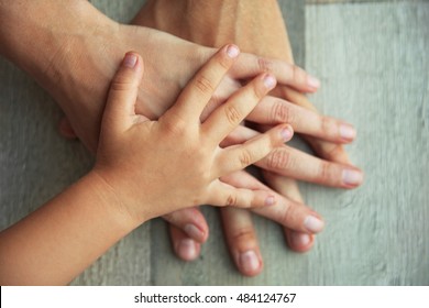 木製の背景に家族の手