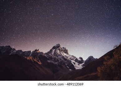 Fantastischer Sternenhimmel. Herbstlandschaft und schneebedeckte Gipfel. Kaukasischer Hauptkamm. Blick auf die Berge vom Berg Ushba Meyer, Georgia. Europa.