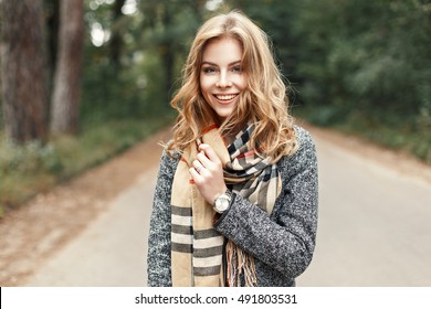Gelukkig Lifestyle-portret van een mooi jong modelmeisje met een lieve glimlach in een warme herfstsjaal.