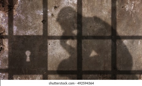 Denkender Mann Schatten unter Gefängnisgittern.