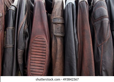 Colección de chaquetas de cuero en perchas en la tienda. Muchas chaquetas de cuero nuevas de invierno para hombres. Textura de fondo y primer plano de cuero de motociclista, chaquetas de motocicleta.