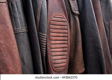 Colección de chaquetas de cuero en perchas en la tienda. Muchas chaquetas de cuero nuevas de invierno para hombres. Textura de fondo y primer plano de cuero de motociclista, chaquetas de motocicleta.