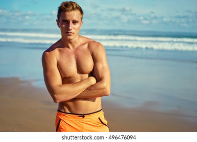 Strong and handsome. Portrait of young caucasian man on the sea beach.
