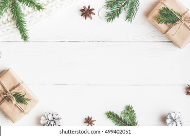 Composición navideña. Regalo de Navidad, manta tejida, piñas, ramas de abeto sobre fondo blanco de madera. Plano, vista superior, espacio de copia