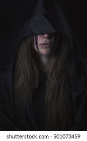 Dark assassin woman, hidden under the hood of her cloak