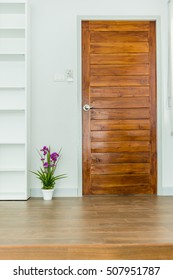 planta artificial con flor violeta cerca de la puerta de madera y suelo