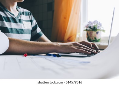 Hombre guapo joven usando una computadora portátil en su oficina