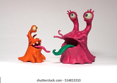 Aus Plastilin geformtes Paar lustige Monsterschnecken. Seine Zunge. Getrennt auf weißen Hintergrundzeichen