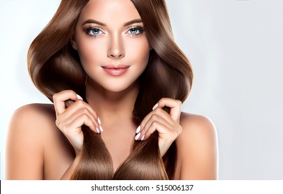 Chica hermosa modelo con cabello largo y recto marrón brillante. Cuidado y productos para el cabello.