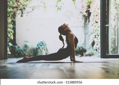 Portret van prachtige jonge vrouw beoefenen van yoga binnen. Mooi meisje praktijk cobra asana in de klas. Rust en ontspanning, vrouwelijk geluk. Horizontale, onscherpe achtergrond