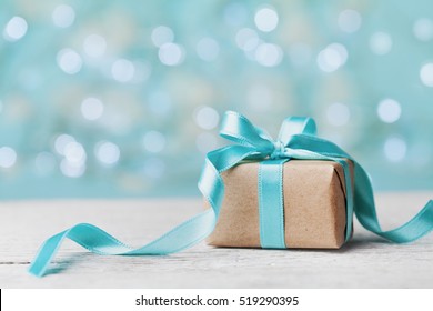 Kotak hadiah Natal dengan latar belakang bokeh pirus. Kartu ucapan liburan.